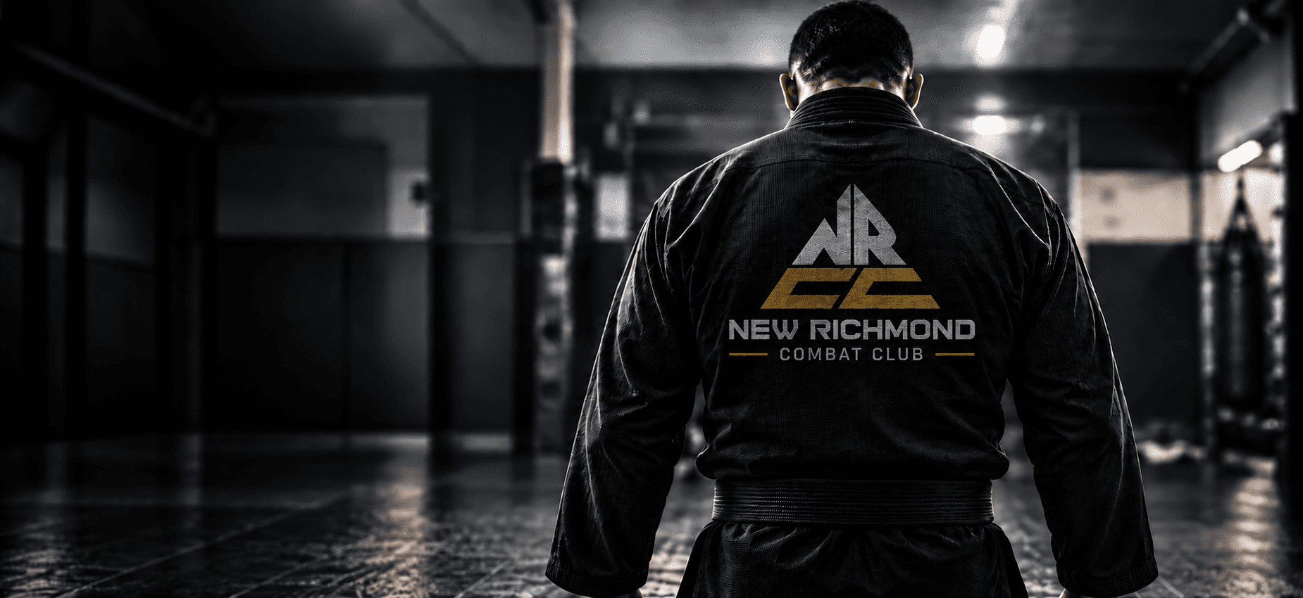 Athlete in a black Brazilian jiu-jitsu gi, triangular New Richmond Combat Club mark on the back